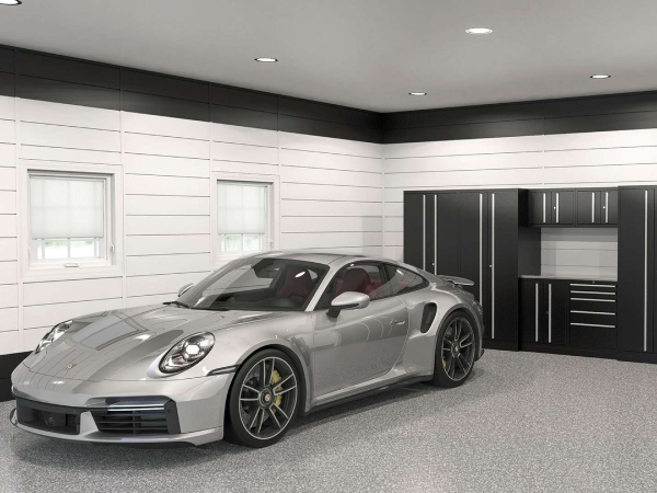 sleek silver sports car parked in garage with recessed ceiling lighting, white slat walls, charcoal cabinetry and a gray polyflake floor